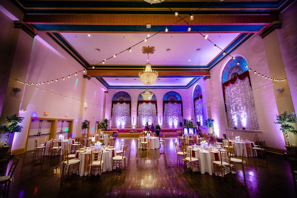 big ballroom large event dancing guests event space event room lights chandeliers table settings party 